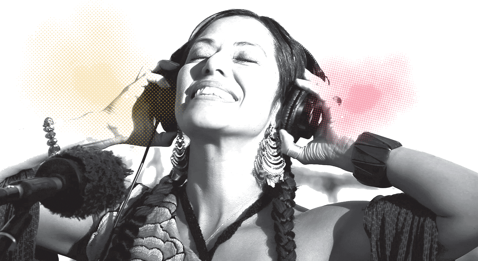 A woman smiling listening to music through headphones.
